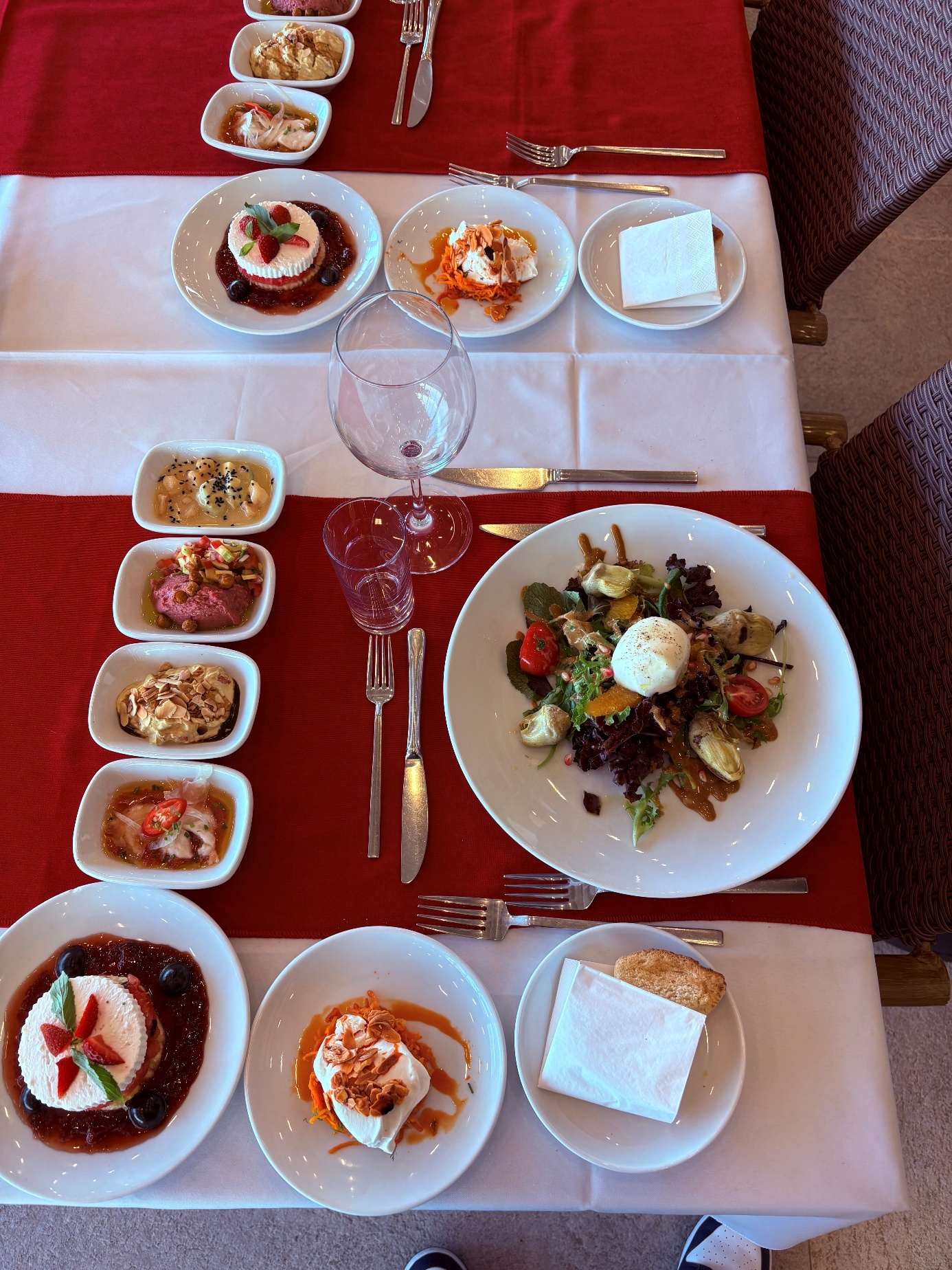 Kırmızı örtülü masada çeşitli meze tabakları