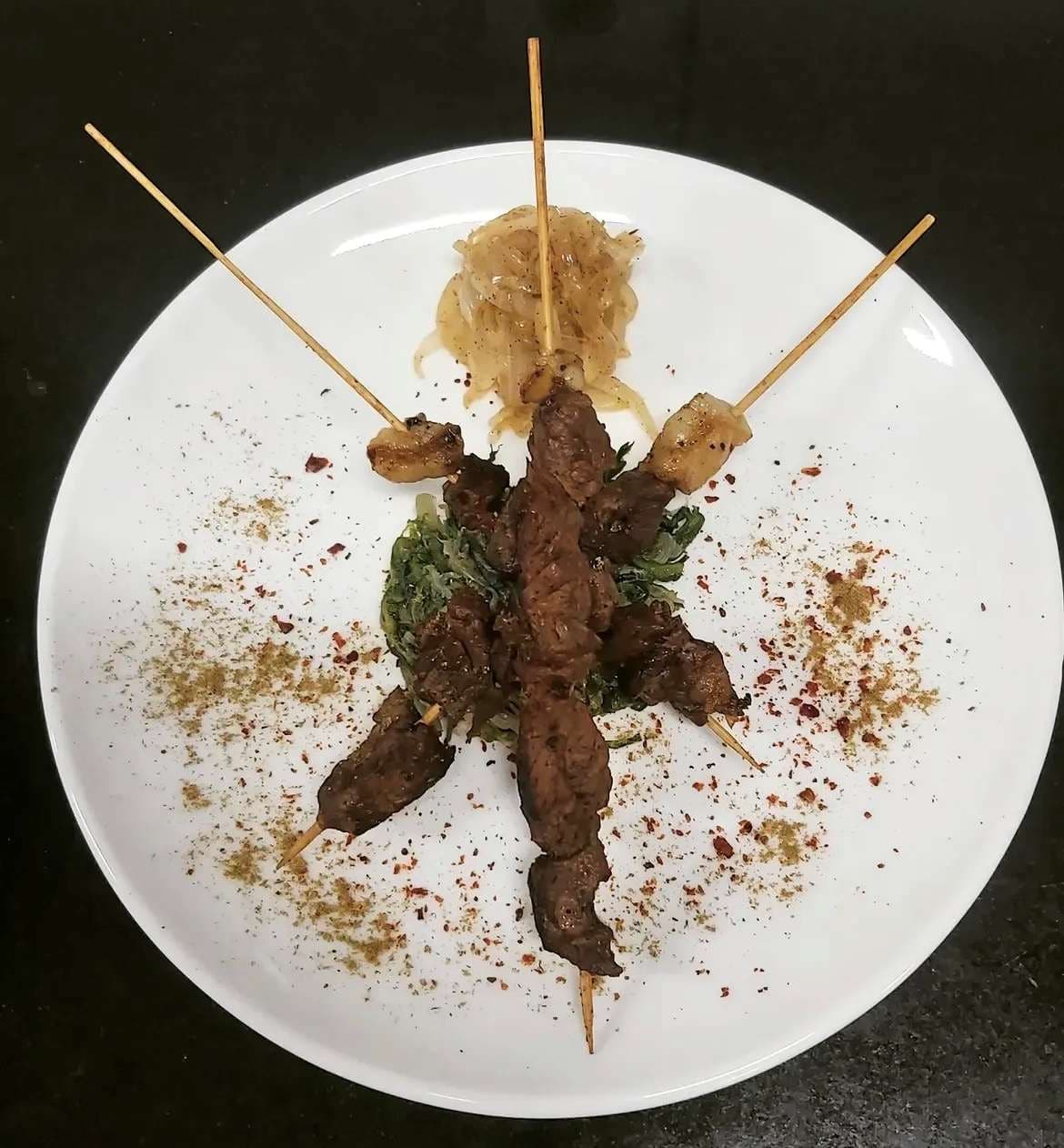Yoğurtlu sos ve baharatlarla şiş kebap sunumu